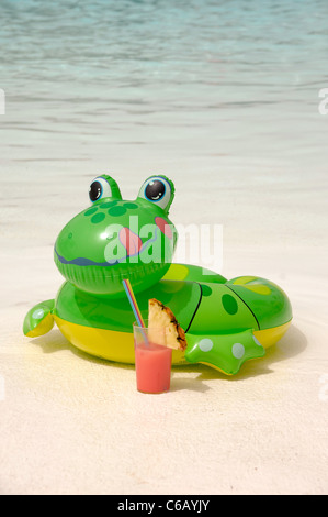 Happy frog is enjoying a cool drink by the pool Stock Photo