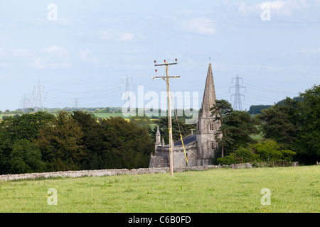 The church of St Bartholomew in the Cotswold village of Aldsworth, Gloucestershire - surrounded by power cables Stock Photo