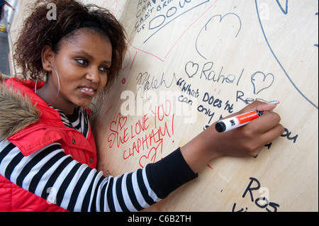 The aftermath of the riots in the Clapham Junction area.  People write messages of support on boards covering damage. Stock Photo