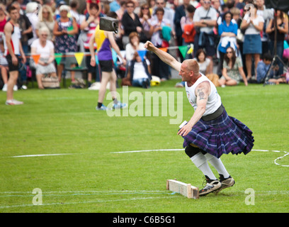 Kilted athlete throwing a 56lb weight during one of the 'heavy events' at Brodick Highland Games, Arran Stock Photo