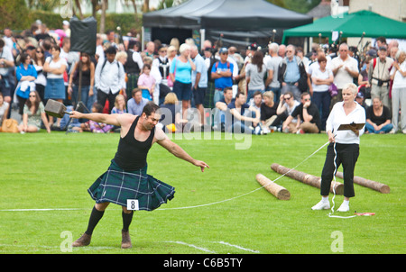 Kilted athlete: 'throwing a 56lb weight' competition, Brodick Highland Games, Arran. An official is ready to measure the throw. Stock Photo