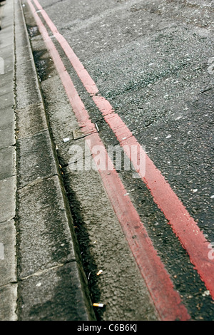 Red Route no stopping lines marking the side of a road in Victoria, London. Stock Photo