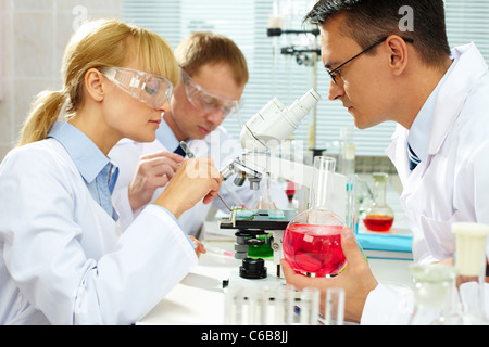 Group of clinicians experimenting with new substance in laboratory Stock Photo