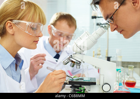 Group of clinicians experimenting with new substance in laboratory Stock Photo