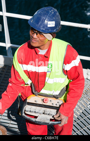 A crane operator using a remote control unit. Stock Photo