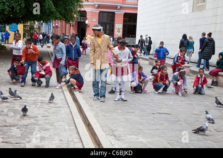 Cuba, Havana. School Children Feeding Pigeons in the Street. Stock Photo