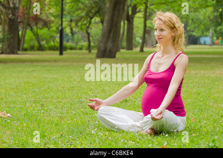pregnant woman relaxing in the park Stock Photo