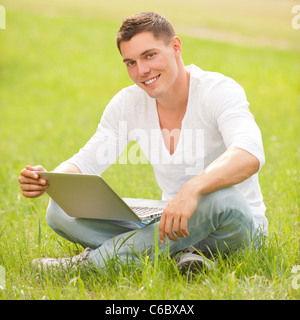 Young man with notebook in the park Stock Photo
