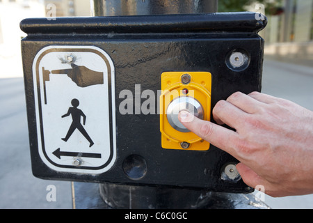 mans hand pressing pedestrian crossing call button downtown winnipeg manitoba canada Stock Photo