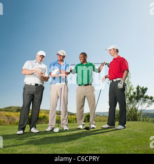Men playing golf together on golf course Stock Photo