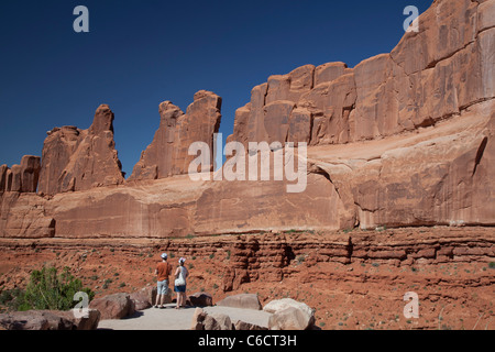 Moab, Utah - A couple looks at one of the walls that make up 'Park Avenue' in Arches National Park. Stock Photo