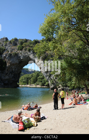 Pont d’Arc rock archway over the Ardeche river Gorges d’Ardeche Gard France with canoes and tourists sunbathing Stock Photo