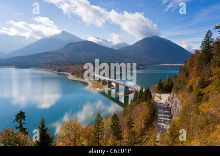 Reflections of a road bridge over Lake Sylvenstein, with mountains in the background, in Bavaria, Germany Stock Photo