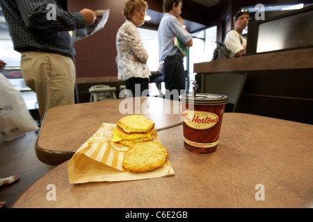 people queueing past medium coffee and breakfast in tim hortons coffee shop canada Stock Photo