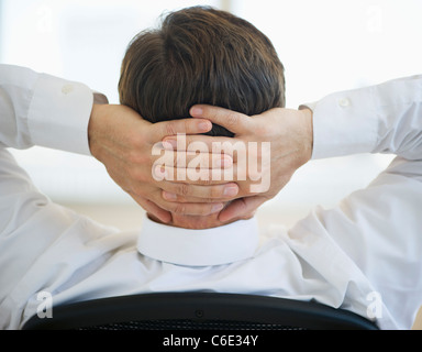 USA, New Jersey, Jersey City, Businessman with hands behind head Stock Photo