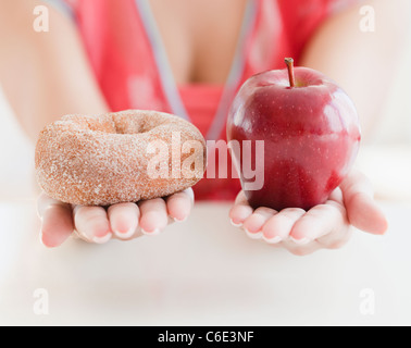 USA, New Jersey, Jersey City, Close up of woman's hands holding donut and apple Stock Photo