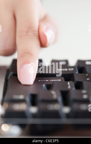 USA, New Jersey, Jersey City, Close up of woman's hand pressing enter key Stock Photo
