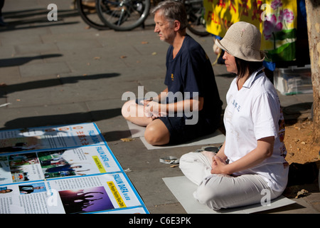 A couple practicing Yoga outdoors, London, England Stock Photo
