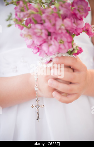 USA, New Jersey, Jersey City, Close up of girl's hands holding flowers and rosary beads Stock Photo
