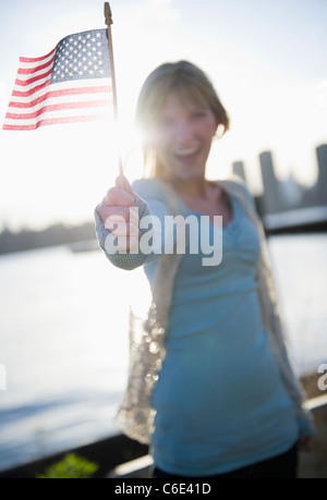 USA, Brooklyn, Williamsburg, Woman holding American flag Stock Photo