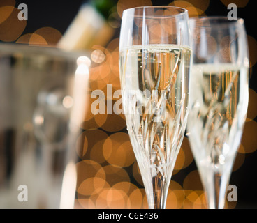 Close up of champagne flutes and ice bucket Stock Photo