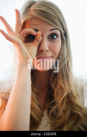 USA, New Jersey, Jersey City, Portrait of blonde woman showing ok sign Stock Photo