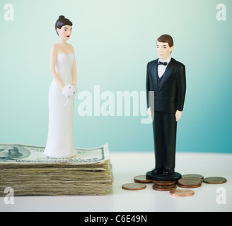 Close up of wedding cake figurines on coins and banknotes Stock Photo