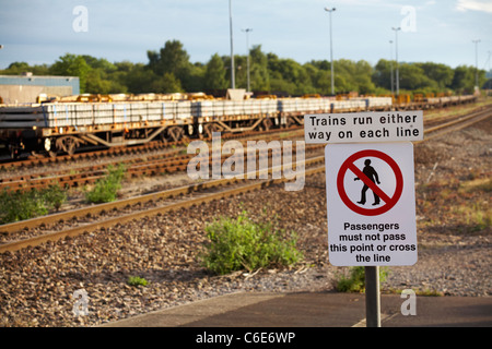 sign on platform at Westbury advising Trains run either way on each line Passengers must not pass this point or cross the line Stock Photo