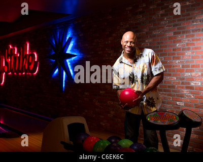 USA, Arizona, Scottsdale, Smiling mature man holding bowling ball Stock Photo