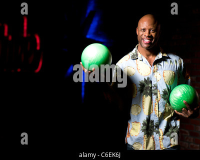 USA, Arizona, Scottsdale, Smiling mature man holding bowling balls Stock Photo