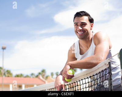 USA, Arizona, Scottsdale, Smiling man standing near tennis net Stock Photo