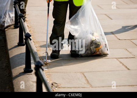 A man collecting rubbish from the street Stock Photo