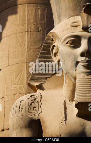 Ancient sitting statue of Ramses II in Luxor Temple lit up at night ...