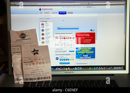 UK lottery tickets being checked online internet lotto and euro millions numbers Stock Photo