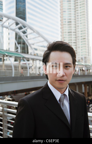 Serious Asian businessman standing outdoors Stock Photo
