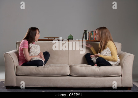 Portrait of teenage girl and young woman sitting on sofa Stock Photo