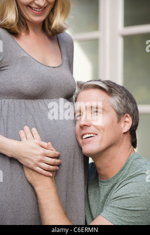 USA, California, Beverley Hills, Man with head next to pregnant woman's belly Stock Photo