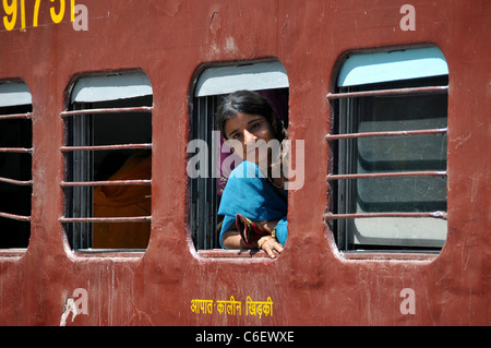 Young girl leaning out of carriage window Aravalli Ranges Rajasthan India