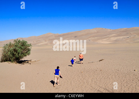 Great Sand Dunes National Park Colorado. Tourists cross the flat sand sheet and climb to the top of the dunes. Stock Photo