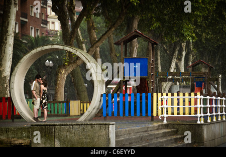 Couple kissing caught in the rain in Bilbao Spain Stock Photo
