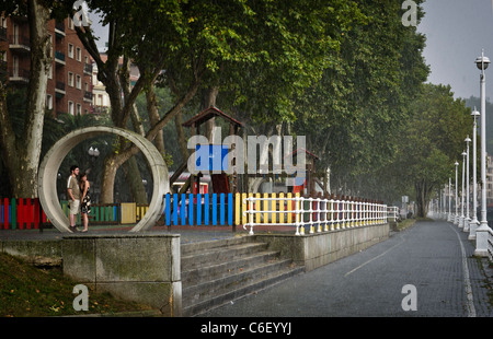 Couple caught in the rain in Bilbao Spain Stock Photo