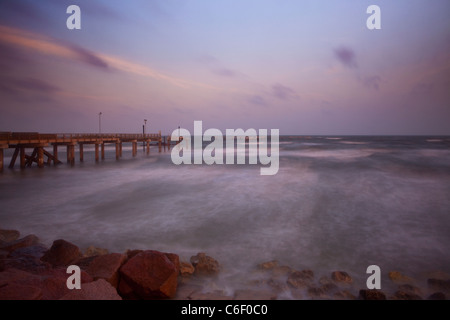 Early morning light with storm clouds at Fishing pier on Seawall Boulevard, Galveston, Texas, Gulf Coast