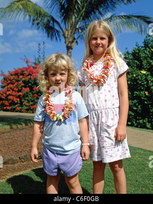 Children wearing leis in hotel garden, Maui, Hawaii, United States of America Stock Photo