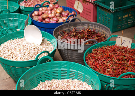 Baskets of fresh cloves of garlic and dried red chillies for sale in the wholesale fruit and vegetable market in Bangkok Stock Photo
