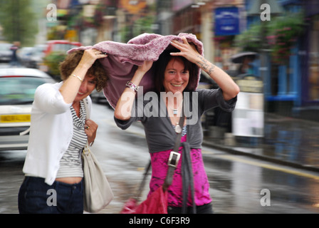 two girls in rainy Glastonbury, United Kingdom Stock Photo