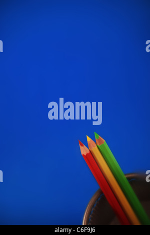 Red Yellow and Green Pencils on a blue background.