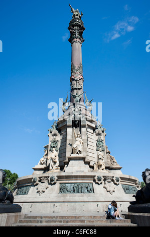 A couple reads its travel guidebook at the bottom of Famous Christopher Columbus' monument in Barcelona city Stock Photo