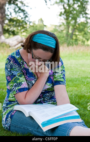 Young lady studying in a park in summertime Stock Photo