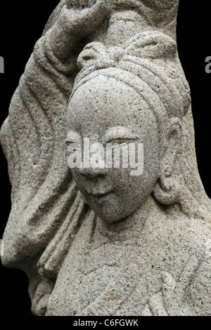 stone carving of an Asian woman from Thai temple with black background Stock Photo