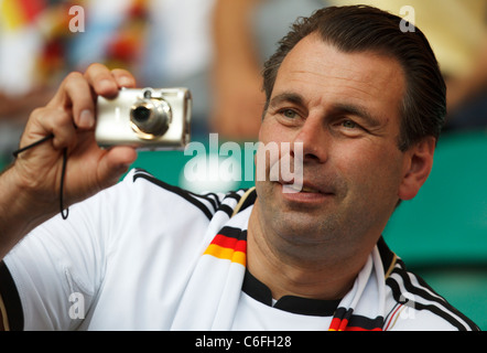 A Germany supporter takes pictures with a compact digital camera at a Women's World Cup quarterfinal soccer match between Germany and Japan. Stock Photo